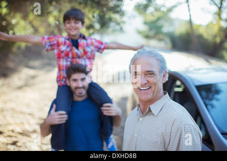 Ritratto di felice multi-generazione di uomini fuori dall'auto Foto Stock