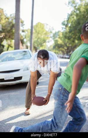 Nonno e nipote a giocare a calcio in strada Foto Stock