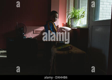 Kiev, Ucraina. 25 Mar, 2014. Un ragazzo dai tartari della Crimea soggiorni con la famiglia nella parte anteriore della finestra nel loro alloggiamento temporaneo vicino a Kiev. © Sergii Kharchenko/NurPhoto/ZUMAPRESS.com/Alamy Live News Foto Stock