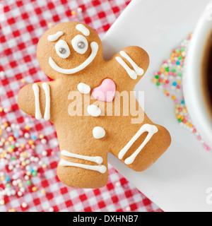 Sorridente omino di pan di zenzero e la tazza di caffè sul tavolo Foto Stock