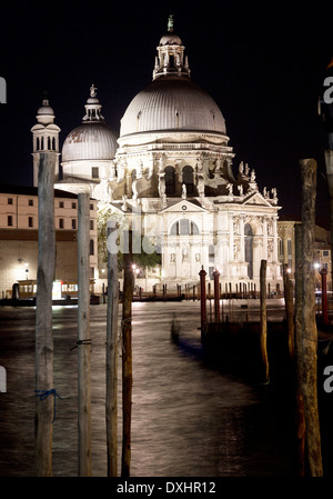 Tempo di notte vista di Santa Maria della Salute Basilica illuminata e si riflette nel canale di Venezia, Italia Foto Stock