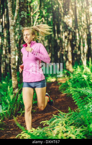 La donna in esecuzione in natura. Corsa su sentiero nella foresta. Attiva uno stile di vita sano concetto di fitness. Foto Stock