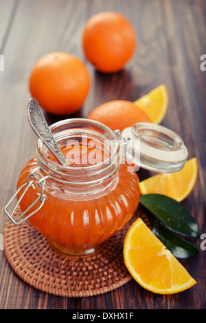 Orange inceppamento nel vasetto di vetro su sfondo di legno closeup Foto Stock