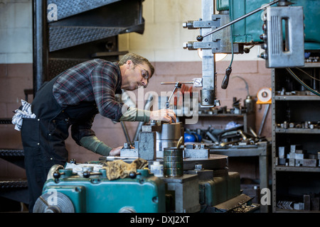 Uomo caucasico lavorando nel negozio di metallo Foto Stock