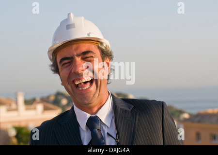 Ridendo imprenditore indossare elmetto Foto Stock