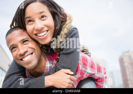 Coppia felice piggybacking Foto Stock