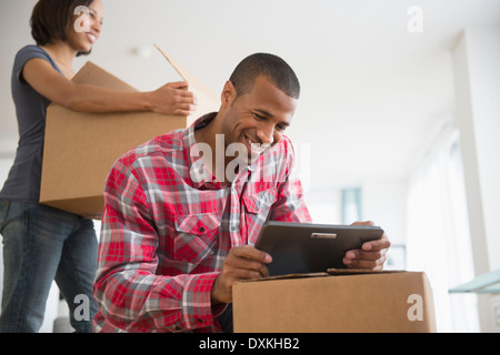 Coppia con tavoletta digitale e contenitori per il trasloco Foto Stock