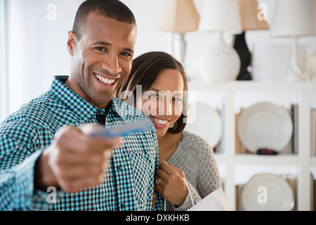 Ritratto di coppia felice di pagare con carta di credito in negozio Foto Stock