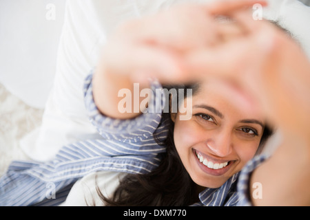 Close up ritratto di sorridere donna asiatica che stabilisce nel letto Foto Stock