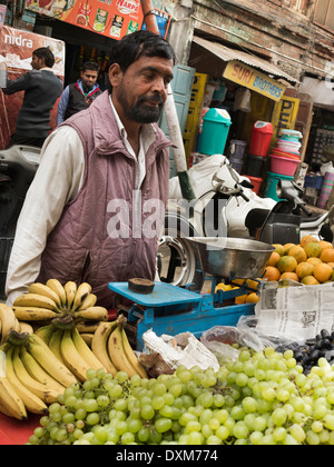 India, Jammu e Kashmir Jammu, Rajinder Bazaar, frutta venditore vendita di uva, banane e arance dalla pressione di stallo Foto Stock