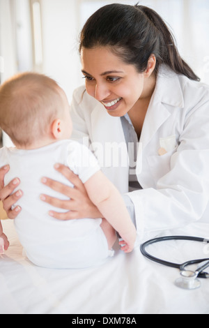 Medico sorridente presso baby Foto Stock