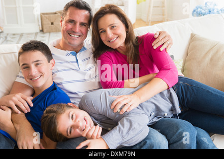 Ritratto di sorridente famiglia caucasica sul divano Foto Stock