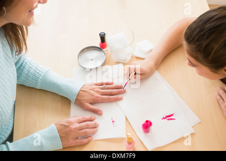 Ragazza caucasica dando madre una manicure Foto Stock