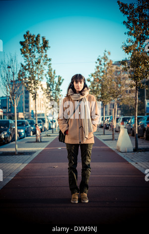 Bella giovane donna ascoltando musica le cuffie nella città inverno Foto Stock