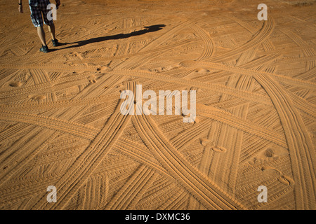 Una serie di tracce di piedi e pneumatici nel deserto Foto Stock