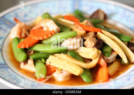 Verdure saltati con gamberi nel piatto. Foto Stock