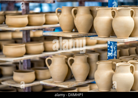 Ripiani con stoviglie in ceramica nel laboratorio di ceramica Foto Stock