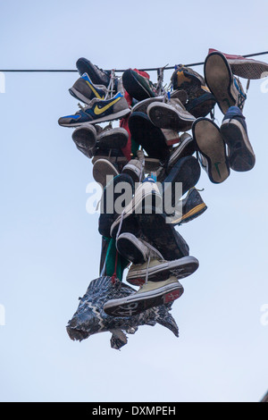 Calzatura scagliare-shoefiti-lancia le scarpe e trainer over Powerline Foto Stock