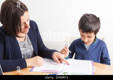 Tutoring genitore giovane ragazzo a casa Foto Stock