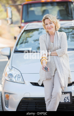 Ritratto di donna sorridente in attesa di assistenza stradale Foto Stock