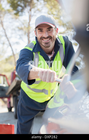 Ritratto di sorridente meccanico sul ciglio della strada Foto Stock