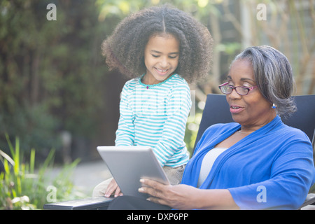 Nonna e nipote con tavoletta digitale all'aperto Foto Stock