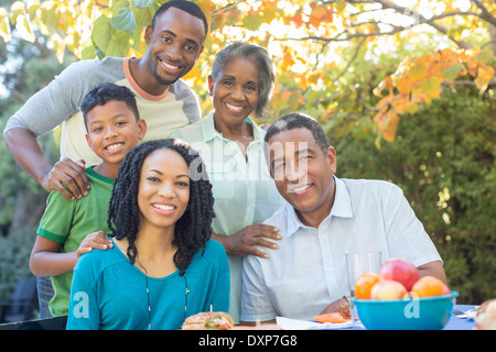 Ritratto di sorridere multi-generazione famiglia presso il patio tabella Foto Stock