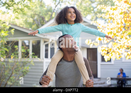 Padre che porta felice figlia sulle spalle Foto Stock