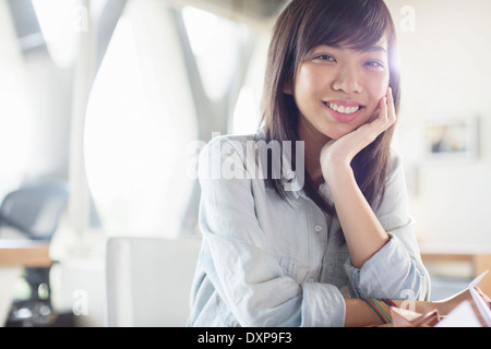 Ritratto di sorridere imprenditrice con testa in mani Foto Stock