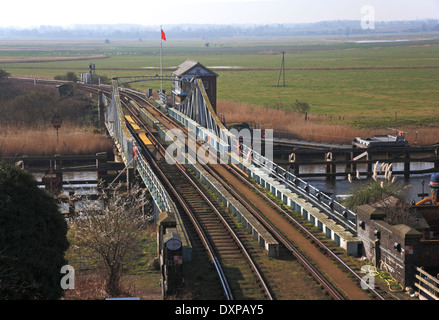 Una vista della Norwich a Lowestoft linea ferroviaria che attraversa il fiume y vengono a Reedham Ponte Girevole, Norfolk, Inghilterra, Regno Unito. Foto Stock