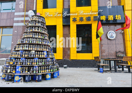 Albero di Natale fatto di impilate le bottiglie di birra e lattine davanti a una birra tedesca house. La città di Jilin, provincia di Jilin, Cina. Foto Stock
