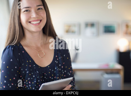 Ritratto di sorridere imprenditrice con tavoletta digitale in ufficio Foto Stock