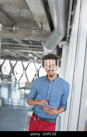 Ritratto di fiducioso casual uomo d affari con tavoletta digitale in ufficio Foto Stock