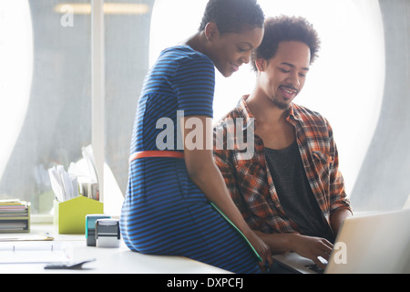 Casual uomo d affari e imprenditrice utilizzando laptop in riunione Foto Stock