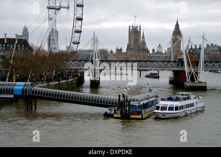 Una vista del fiume Tamigi a Londra guardando verso le case del parlamento con il London Eye in background Foto Stock