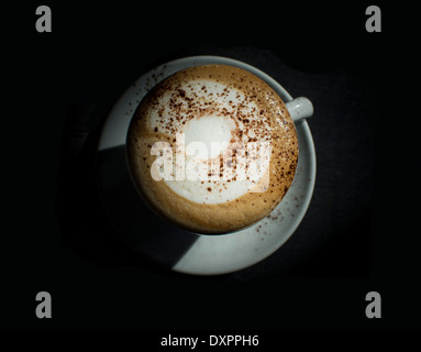Capucchino nel buio isolato sul nero. Foto Stock