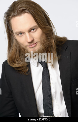Un lunghi capelli uomo, maschio modello con la barba che indossa cravatta e tuta close-up verticale headshot Foto Stock