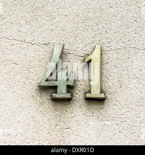 Casa di metallo numero quaranta uno sul grigio di un muro di cemento Foto Stock