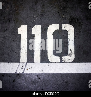 Numero centodieci, verniciato a spruzzo sul pavimento del garage Foto Stock