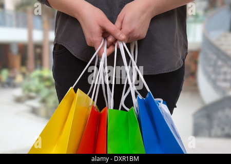 Giovane donna di colore di contenimento delle borse per lo shopping in un centro commerciale per lo shopping in mano Foto Stock