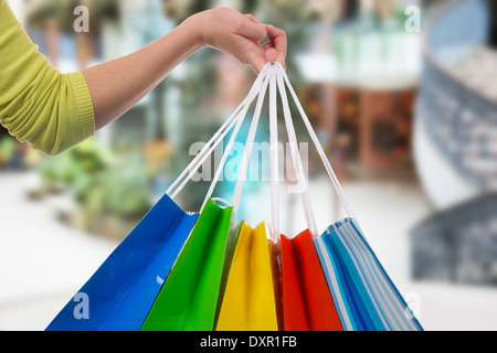 Giovane donna tenendo le borse della spesa in mano in un centro commerciale per lo shopping Foto Stock