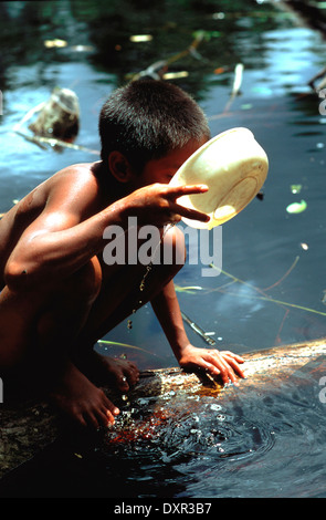 Un bambino Warao acqua potabile nel Delta Orinoco. I Warao sono un popolo indigeno che abitano nel nordest del Venezuela e west Foto Stock