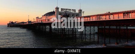 Alba colori sopra la Brighton Palace Pier, città di Brighton e Brighton & Hove, Sussex County, England, Regno Unito Foto Stock