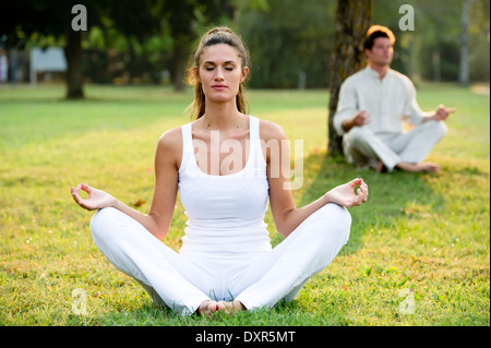 Coppia giovane meditando in posizione di parcheggio Foto Stock