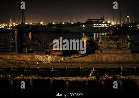 Manila, Filippine. 29 Mar, 2014. Un pescatore si appoggia a un dock durante l Ora della Terra nella baia di Manila, Filippine, 29 marzo 2014. La Earth Hour blu, un progetto lanciato dal Fondo mondiale per la natura (WWF), ha lo scopo di stimolare i partecipanti a sostenere finanziariamente le comunità in tutto il mondo attraverso le campagne ambientali. Una parte dei proventi del progetto sarà integrata in barche a motore per le famiglie nei villaggi costieri nelle Filippine che sono state colpite da Super Typhoon Haiyan nel novembre dello scorso anno.Foto: Ezra Acayan/NurPhoto Credito: Ezra Acayan/NurPhoto/ZUMAPRESS.com/Alamy Live ne Foto Stock