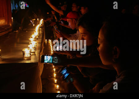 Manila, Filippine. 29 Mar, 2014. Ora della Terra degli avvocati di scattare foto delle candele accese durante le luci spente evento in Makati City. -- Centinaia di Earth Hour avvocati hanno partecipato le luci spente .cerimonia nel cuore di Makati business district. Ora lunga .lo spegnimento delle luci è una iniziativa globale per informare le persone circa .il riscaldamento globale e la conservazione dell'energia. Credito: J Gerard Seguia/NurPhoto/ZUMAPRESS.com/Alamy Live News Foto Stock