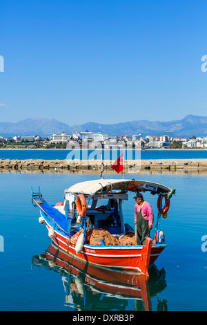 Barca da pesca nella città vecchia porto guardando verso le spiagge e hotel zona ad ovest della città, laterale, Provincia di Antalya, Turchia Foto Stock