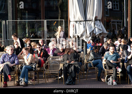 I turisti seduti in un cafe' sul marciapiede sulla Rembrandt Square Amsterdam Paesi Bassi Foto Stock