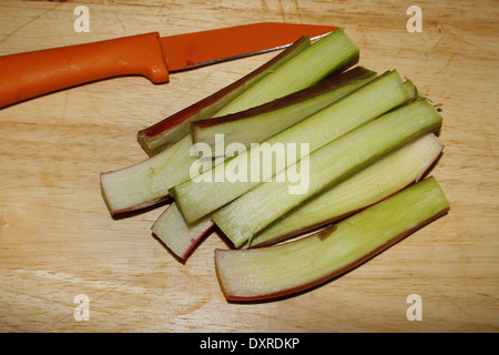 Gli stocchi di rabarbaro sul tagliere Rheum rhabarbarum Foto Stock