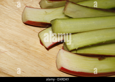 Gli stocchi di rabarbaro sul tagliere Rheum rhabarbarum Foto Stock